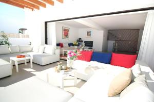ein Wohnzimmer mit weißen Möbeln und roten und blauen Kissen in der Unterkunft 4 bedrooms house with private pool terrace and wifi at Sant Josep de sa Talaia 3 km away from the beach in San Jose de sa Talaia