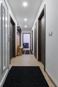 pasillo con puertas de madera y alfombra en Gyöngy Apartman, en Pécs
