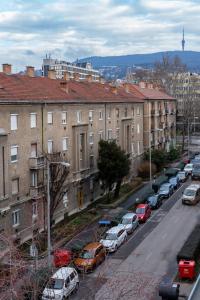 eine Stadtstraße mit Autos, die vor den Gebäuden geparkt sind in der Unterkunft Gyöngy Apartman in Pécs