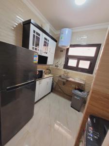 een keuken met een zwarte koelkast en een raam bij High apartment in madinaty in Madinaty