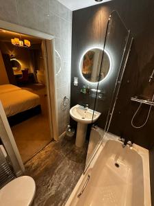 a bathroom with a toilet and a sink and a tub at The George Hotel Easingwold in Easingwold