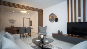 een woonkamer met een bank, een tv en een tafel bij Mountain Vista Residence in Kalabaka