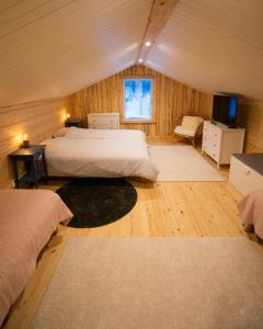 a bedroom with two beds and a television in it at Blueberry Lodge 8 personnes in Mjölan