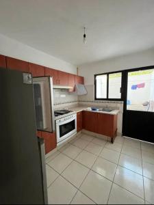 a kitchen with brown cabinets and a white tile floor at Chaka2 in Tonalá