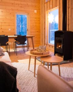 a living room with a woodburning stove in a cabin at Blueberry Lodge 8 personnes in Mjölan