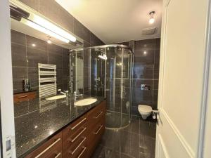 een badkamer met een glazen douche en een wastafel bij Center Park in Interlaken