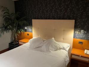 una camera da letto con un grande letto bianco con due comodini di Coto Real a Rábade