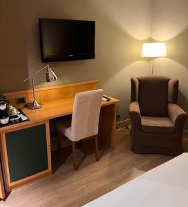 Pokój hotelowy z biurkiem, krzesłem i telewizorem w obiekcie Coto Real w mieście Rábade