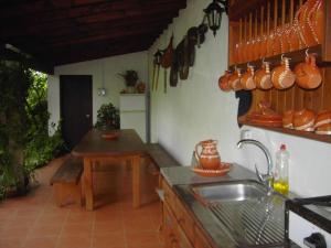 a kitchen with a sink and a table and utensils at 2 bedrooms house with shared pool enclosed garden and wifi at Ponte de Lima in Ponte de Lima
