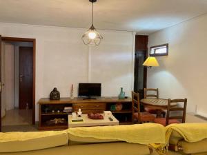 a living room with a couch and a tv at 2 bedrooms house with shared pool enclosed garden and wifi at Ponte de Lima in Ponte de Lima