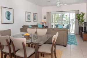 a dining room and living room with a glass table and chairs at Callie Kai at Kaibo Yacht Club in Driftwood Village