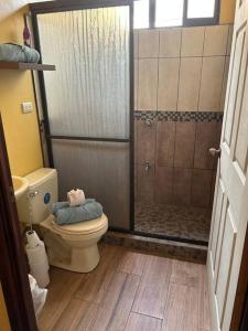 a bathroom with a toilet and a shower at Casa Sendero in Liberia