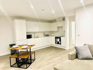 a living room with a table and a kitchen at Town Center Luxury Apartment next to the Beach in Kent
