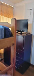 a bedroom with a bunk bed with a flat screen tv at Apartamento confort centro in Pasto