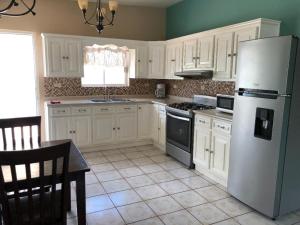 a kitchen with white cabinets and a white refrigerator at Almejas B in San Carlos