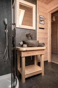 a wooden bathroom with a sink and a shower at Wooden Chalet WRÓBLOWA CHAŁUPKA przy Dolinie Chochołowskiej in Witów