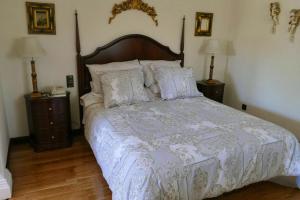 un letto in una camera da letto con due comodini e due lampade di 5 bedrooms house with private pool jacuzzi and terrace at Salamanca a Villamayor