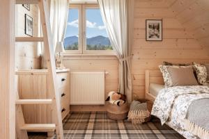 a bedroom with a bed and a window at Wooden Chalet WRÓBLOWA CHAŁUPKA przy Dolinie Chochołowskiej in Witów