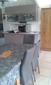 uma cozinha com uma mesa, 2 cadeiras e um micro-ondas em Propriete de 2 chambres avec terrasse et wifi a Liginiac a 5 km de la plage em Liginiac