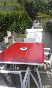 uma mesa vermelha com um prato em cima em Propriete de 2 chambres avec terrasse et wifi a Liginiac a 5 km de la plage em Liginiac
