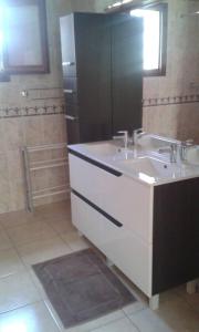 uma casa de banho com um lavatório branco e um espelho. em Propriete de 2 chambres avec terrasse et wifi a Liginiac a 5 km de la plage em Liginiac