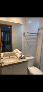 Un baño con lavabo, inodoro y espejo. en Veredas do Rio Quente Apart, en Rio Quente
