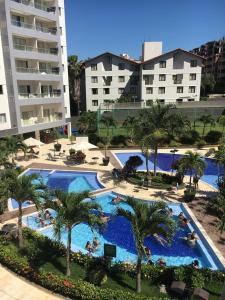 Una vista aérea de una piscina con palmeras y edificios. en Veredas do Rio Quente Apart, en Rio Quente