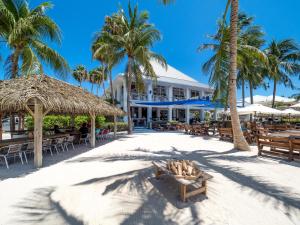 un resort sulla spiaggia con sedie e palme di Colonial Kai Condo a Driftwood Village