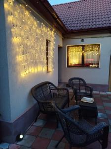 eine Terrasse mit Stühlen und Lampen an der Wand in der Unterkunft Milu Residence 2 in Ghimbav