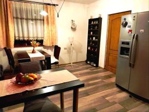 eine Küche und ein Esszimmer mit einem Tisch und einem Kühlschrank in der Unterkunft Milu Residence 2 in Ghimbav