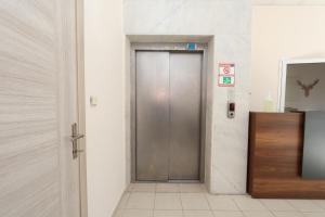 a metal door in a hallway with a tiled floor at Blue Life Hotel in Konak