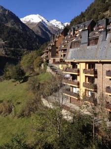 a group of buildings on a hill with snow covered mountains at 2 bedrooms appartement with terrace and wifi at Arinsal in Mas de Ribafeta