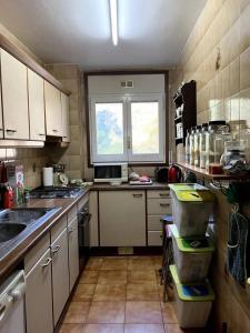 uma pequena cozinha com armários brancos e uma janela em 2 bedrooms appartement with terrace and wifi at Arinsal em Mas de Ribafeta