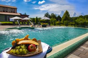 a plate of fruit next to a swimming pool at Hotel Forest Hills in Zirc