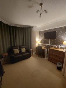 a living room with a couch and a desk at Westfield House in Blackpool