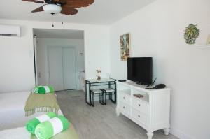 a living room with a tv on a white dresser at The Banana Bird at Cottages in Sand Bluff