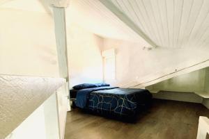 um quarto no sótão com uma cama e uma janela em Appartement sous les toits em Narbona
