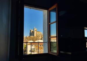 uma janela aberta com vista para um castelo em Appartement sous les toits em Narbona