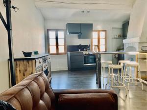 uma cozinha com um sofá e uma mesa num quarto em Appartement sous les toits em Narbona