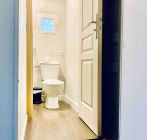 uma casa de banho com um WC branco e uma porta em Appartement sous les toits em Narbona