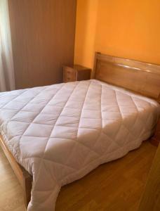 duże białe łóżko w sypialni z drewnianym zagłówkiem w obiekcie Pomares Country House w mieście Melgaço