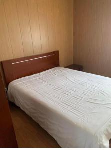 1 dormitorio con cama blanca y cabecero de madera en Pomares Country House, en Melgaço