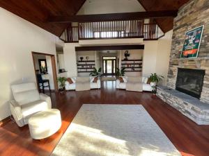 a living room with a stone fireplace and white chairs at For a private, stunning vacation home or retreat in Lancaster