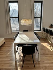 a white dining room table with chairs and a chandelier at Luxe Spacious SFH in Bucktown with Secure Parking in Chicago