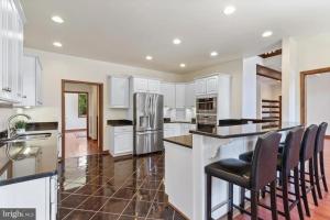 a kitchen with white cabinets and black counter chairs at For a private, stunning vacation home or retreat in Lancaster