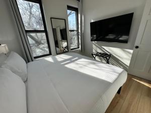 a bedroom with a large white bed and two windows at Luxe Spacious SFH in Bucktown with Secure Parking in Chicago