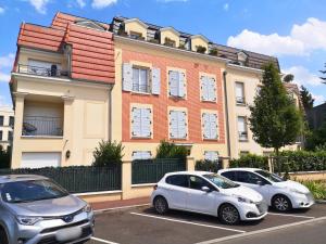 zwei weiße Autos auf einem Parkplatz vor einem Gebäude geparkt in der Unterkunft Maison de Charme - parking gratuit près de Paris & métro in Villejuif