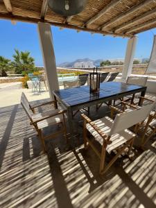 una mesa y sillas en una terraza con vistas al océano en VILLA THEIA - SELENE , appartement de charme pour 4 à 6 personnes prés de la plage et du village de Koufonissi, en Koufonisia