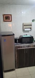 a kitchen with a refrigerator and a printer on a counter at Apartamento confort centro in Pasto