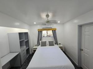 a bedroom with a white bed and a window at Casa Margarita in First Bight